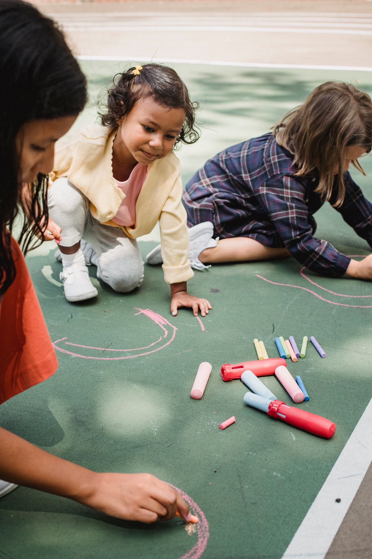 Children drawing together with sidewalk chalk